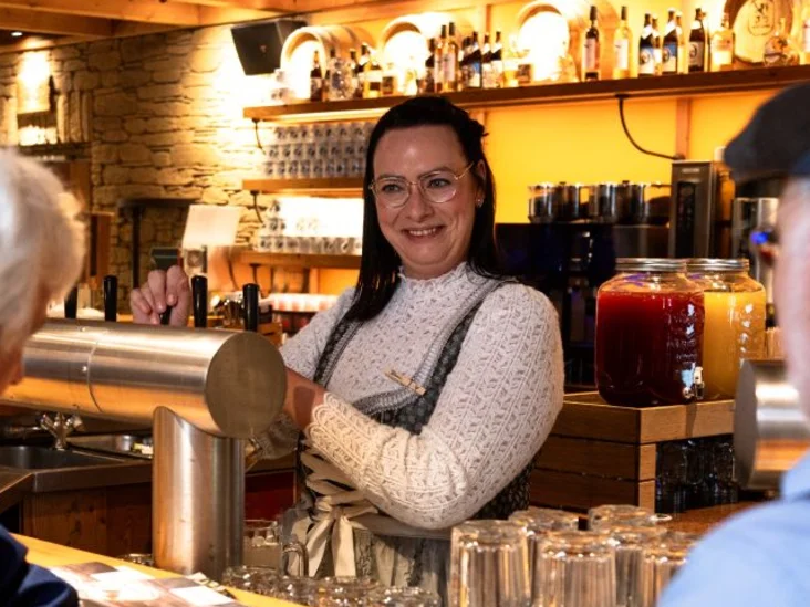 Gäste an der Bar einer Bavaria Alm