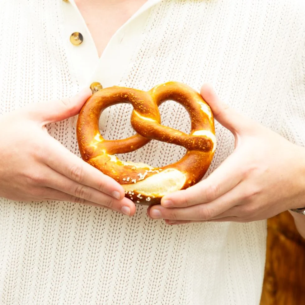 Nahaufnahme eines Gastes mit einer Brezel in seinen Händen